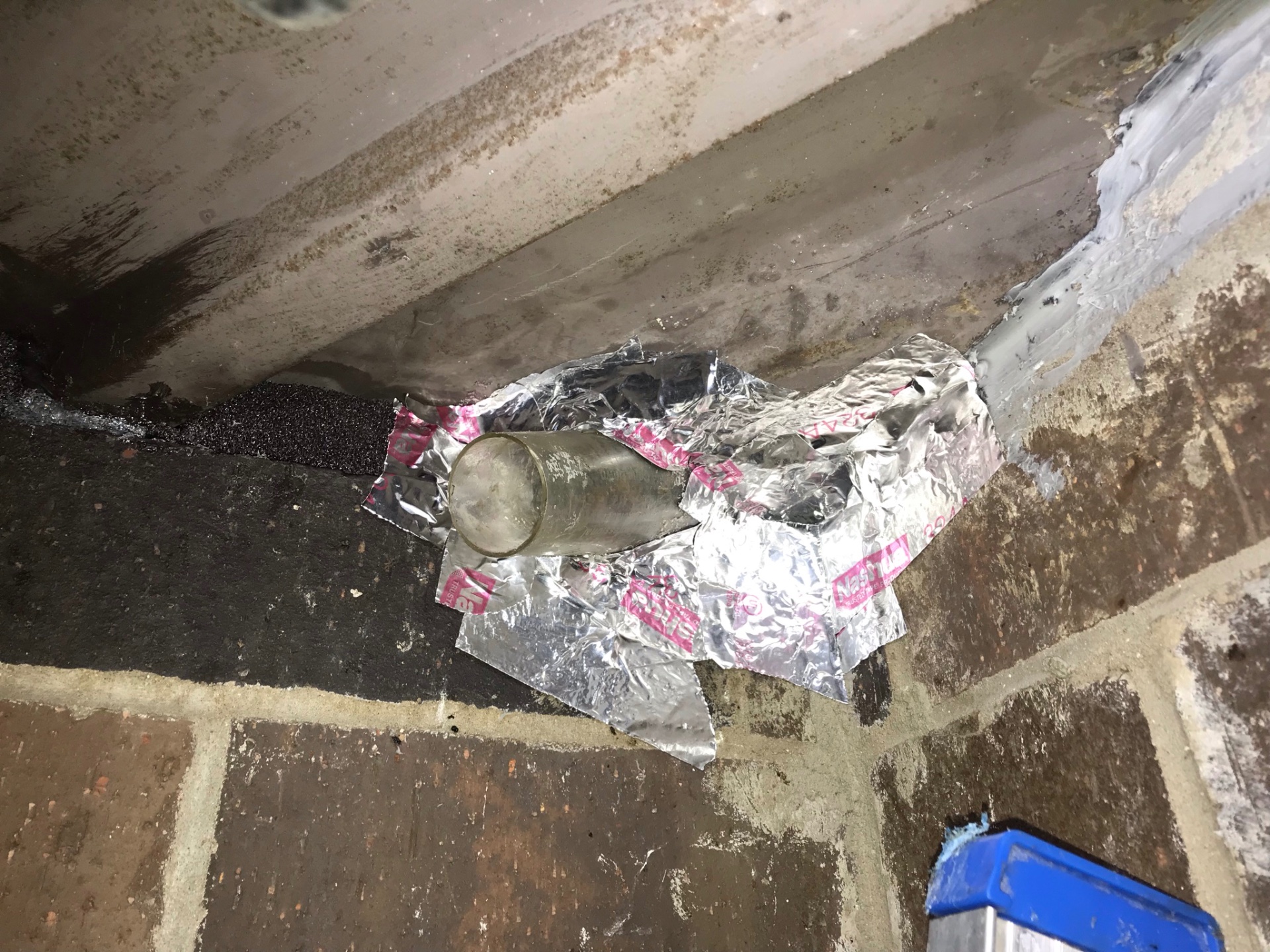 One-way bat excluder installed over an entry point on a brick building